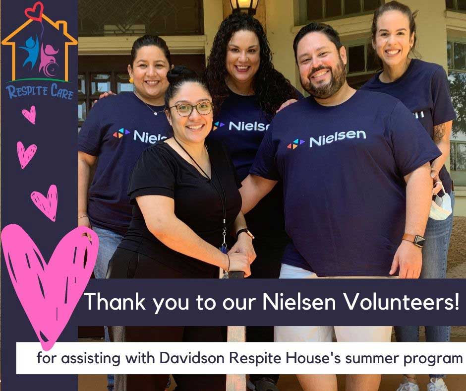 Voluntarios con Nielsen sonriendo delante de la Davidson Respite House