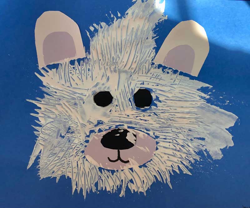 Child's painting of a polar bear on blue background