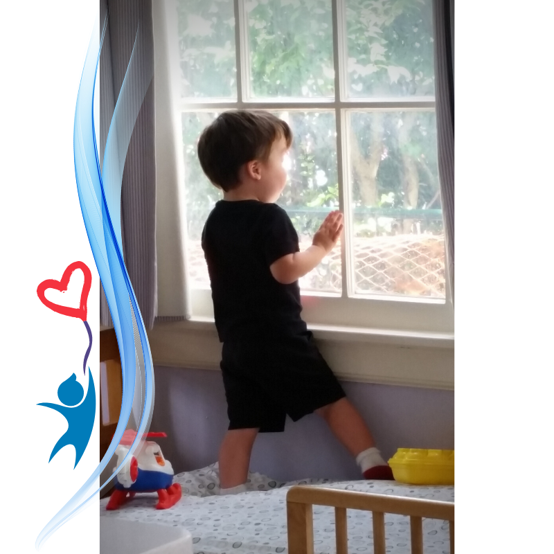 Toddler boy looks out the window